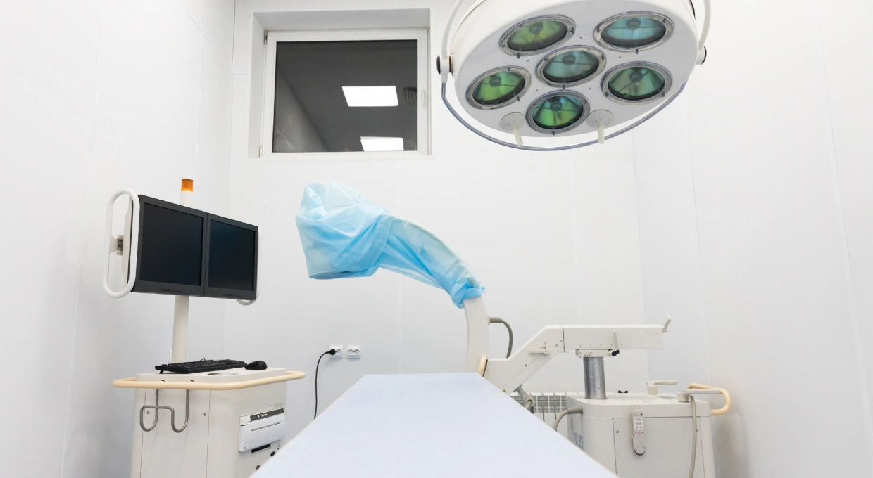 Operating theatre with a surgical lamp, operating table and fluoroscopy monitor, set up for percutaneous foot surgery under local anaesthetic
