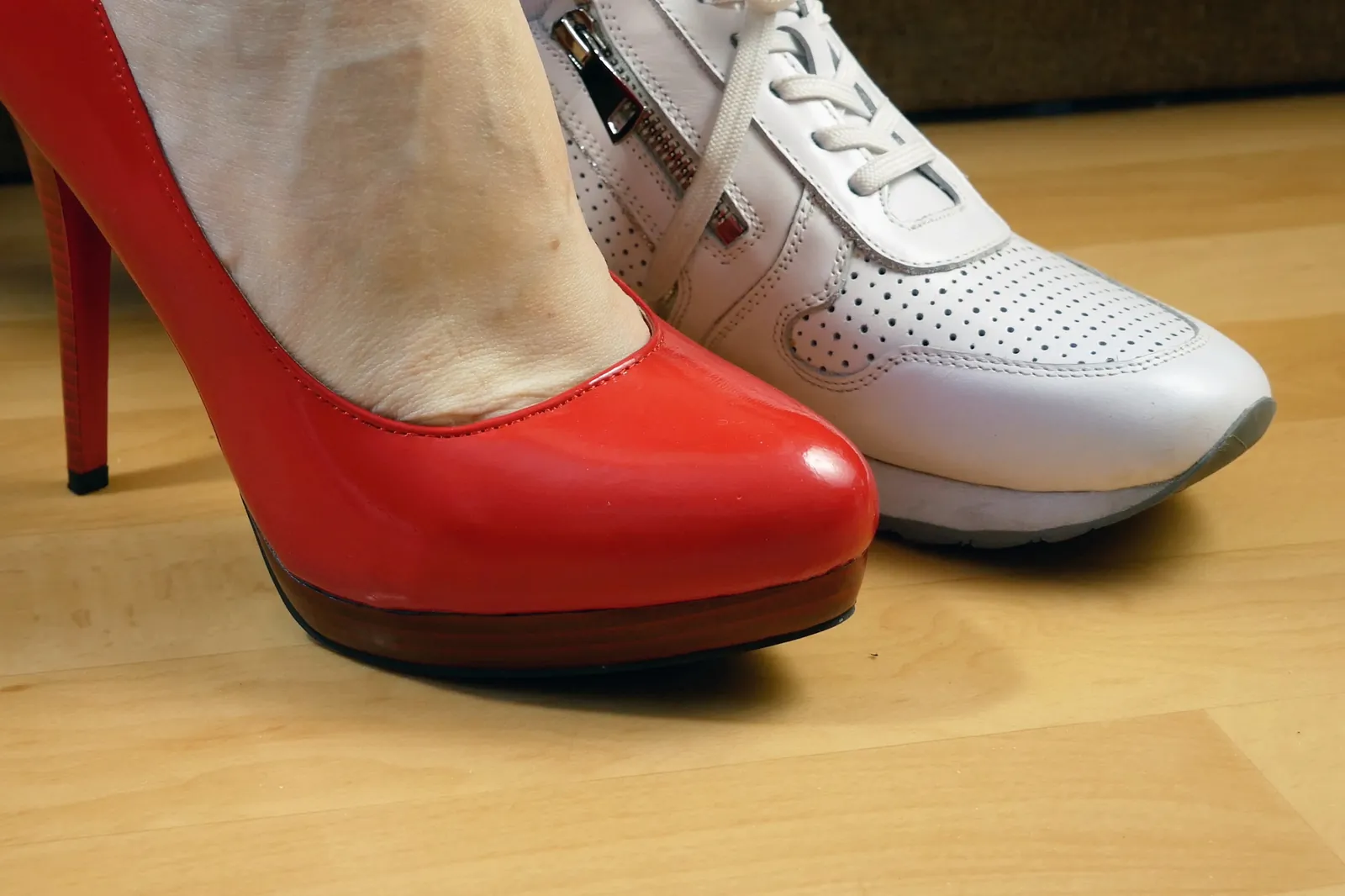Zapato rojo de tacón alto frente a una zapatilla blanca de horma ancha